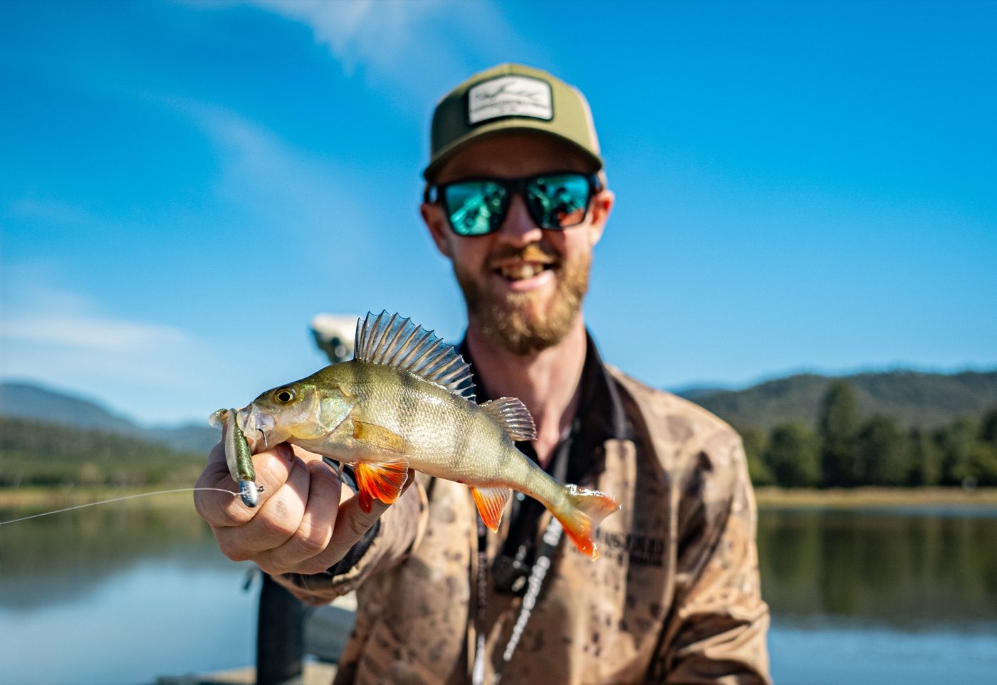 A redfin held at the water with a Rapala CrushCity soft plastic still in its mouth